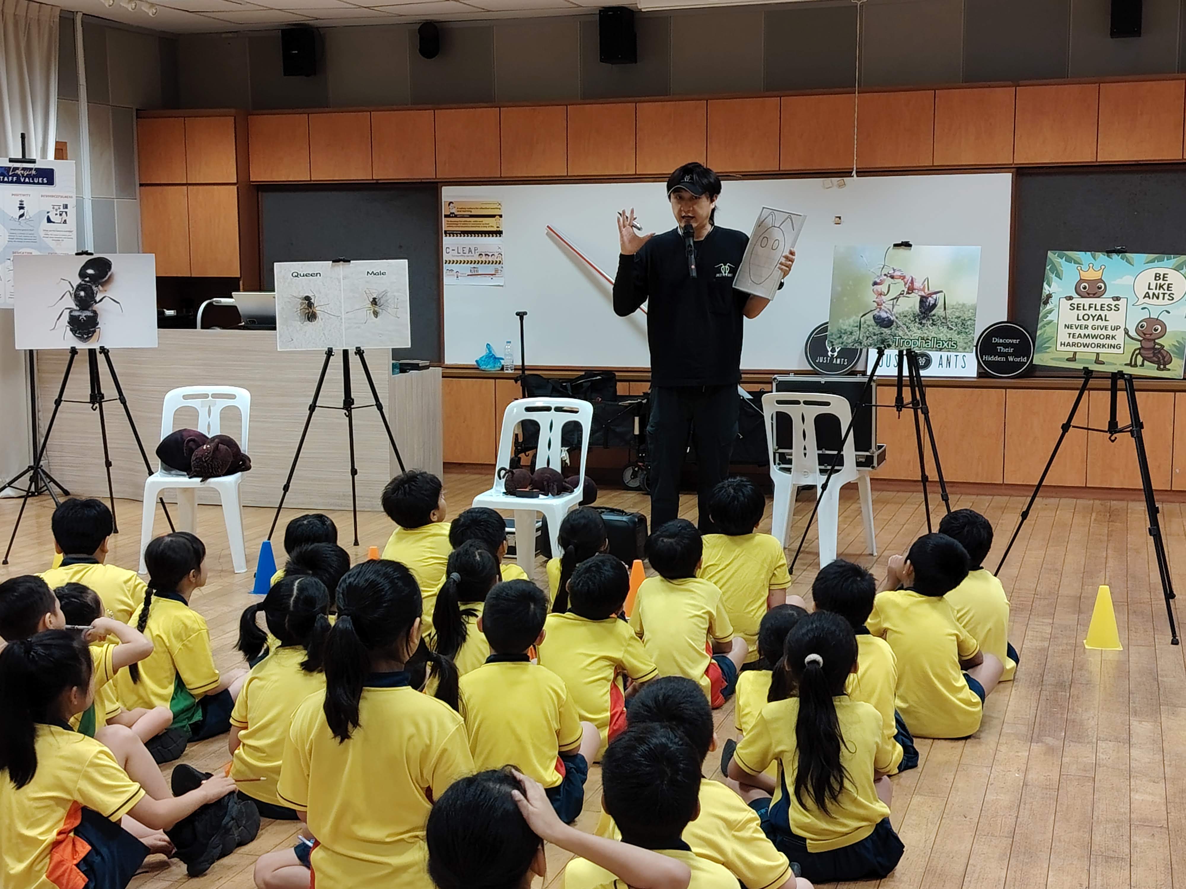 P1 students gathered in front of Mr John the Ant keeper as he teaches the students about ants through magic and fascinating stories